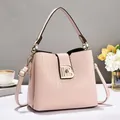 Detalle de bolso tipo cubo rosa pálido con textura tejida, hebilla B y correa - Rosa
