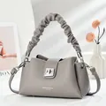 Detalle del bolso de cuero gris con asa plisada tipo nube y cierre de metal plateado - Gris