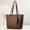 Detail of dark brown pebble leather tote bag with logo tag and mini matching charm pouch - Coffee