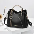 Schwarze Lederhandtasche mit Kontrastnähten, Goldgriff und Herzanhänger mit Quaste - Schwarz