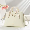 Detail of cream white leather handbag with silk scarf wrapped handle and gold hardware - White