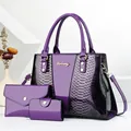 Detailed close-up of purple snake pattern textures and golden logo on fashion bag set - Purple