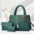 Detail of dark green tote bag set with crocodile texture and gold hardware accents - Three-Piece Set / Green