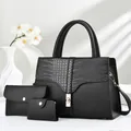 Detalle del bolso negro con textura de cocodrilo y cierre de giro en metal dorado liso - Set de 3 piezas / Negro
