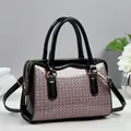 Détail du motif tissé à paillettes violettes et cuir verni noir sur le sac à main - Rose