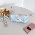 Detailed view of blue checkered pencil case with embroidered pink bow and top zipper - Blue Plaid
