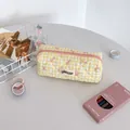 Close-up of yellow checkered quilted pencil case with pink bow prints and zipper - Yellow Check