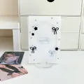 Primer plano de soporte acrílico para tarjetas K-pop con patrones de lazos y estrellas - Blanco con Lazo