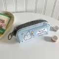 Dettaglio dell'astuccio in tela azzurra con pulcino cartone e grande cerniera grigia lampo - Blu