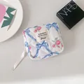 Détail d'une trousse à maquillage matelassée fleurie avec roses roses et nœud élégant - Bleu