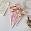 Flat lay of eight pink rose flower pens arranged on a desk with elegant props - Pink