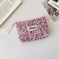 Detailed macro of pink quilted fabric storage bag with ink splash pattern and brand label - Rose Red