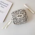 Detail of quilted small square storage bag with ink spot pattern and cream ribbons - Black and White Splatter