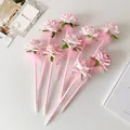 Detalle de rosa artificial y pluma en bolígrafos rosas para regalo romántico - Rosa