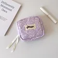 Detail of purple quilted mini bag with ink splash pattern and white ribbon zipper pulls - Splatter Light Purple