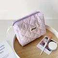 Detailed top view of light purple quilted cosmetic bag with white splash ink texture - Purple