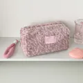 Detail van de pluchen make-uptas met luipaardprint en zachte roze ritsafwerking - Roze Bruin