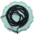 Cuentas redondas de cristal negro tallado para joyería DIY en un plato azulado - Cristal Negro