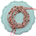 Perle in quarzo fragola sfaccettato con inclusioni rosse su base decorativa blu - Super Seven Nero