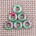Detailed view of six ruby zoisite donut pendants with natural green and red textures - Ruby Zoisite