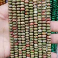 Handheld view of natural Unakite rondelle beads with green and red spots for jewelry making - Unakite