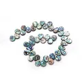 Macro view of teardrop abalone shell beads with iridescent green and blue colors - 8X10mm