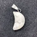 White turquoise crescent moon stone pendant with silver clasp on textured background - Howlite