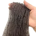 Gefacetteerde grijze kwarts kralenstrengen in de hand gehouden voor DIY sieraden - Rookkwarts