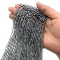 Gefacetteerde ronde kralen van 2-3 mm labradoriet met blauwe en gele glans op wit - Flitssteen (Labradoriet)