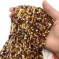 Faceted natural tiger eye and amethyst loose beads held in hand for DIY jewelry making - Yellow Jasper