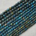 Macro detail of blue and yellow malachite style round beads on textured fabric - 6mm / Blue