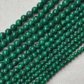 Macro shot of malachite beads showing natural green banded patterns and varied sizes - 6mm / Green