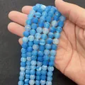 Hand holding blue dragon vein agate round beads for DIY handmade jewelry crafts - Blue