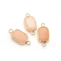 Close-up of rectangular light pink stone connectors with gold edges and double bail loops - Rectangular Double Loop Connector / Pink Aventurine