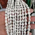 Hand holding white howlite teardrop loose beads with natural grey texture for DIY jewelry - Howlite