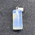 Rectangular opal pendant with silver metal bail on a grey textured background - Milky White Translucent (Opal)