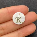 Golden letter K engraving on a circular white natural shell charm pendant for DIY jewelry - Letter K