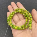Polierte 8-10 mm grüne Jaspis-Rundperlen mit natürlichen braunen Adern in der Hand - Smaragdgrüne Textur