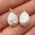 A pair of Baroque freshwater pearl pendants with gold bails held in hand for jewelry DIY - Freshwater Pearl