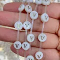 Handheld view of 8mm white shell bead with a golden letter V for DIY jewelry making - 8mm / Letter V