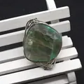 Irregular green agate wire wrapped ring with silver metallic frame on a white bench - Green