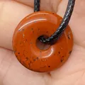 Natural red jasper flat round pendant with black weave cord on a hand model - Red Jasper (10)
