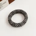 Elastic knit checkerboard hair scrunchie with a black and beige zebra pattern texture - Plaid
