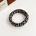 Elastic knit hair tie featuring a geometric black and beige checkered pattern - Greek Key Geometry