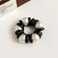 Coletero en espiral con detalles negros brillantes y perlas blancas elegantes - Negro