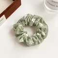 Sage green floral scrunchie with white flower print and soft elastic fabric - Green