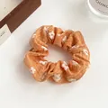 Chic orange floral scrunchie with white daisy patterns for trendy ponytail styles - Orange