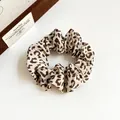 Coletero clásico con estampado de leopardo en tonos beige y marrón sobre libro - Leopardo Café / Marrón