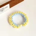 Elastic color-block scrunchie in yellow and blue fabric with a smooth resin bead detail - Yellow