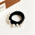 Elastic black hair tie with white faux pearls in different sizes on white background - Black